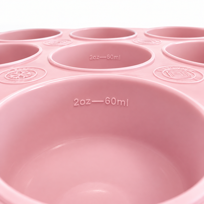 Nærbilde av Trollefant fryseform i rosa med 60 ml-merking i koppene og fryse- og mikrobølgesymboler, sett fra lav vinkel